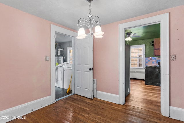 dining room featuring dark wood-type flooring, independent washer and dryer, water heater, and a chandelier