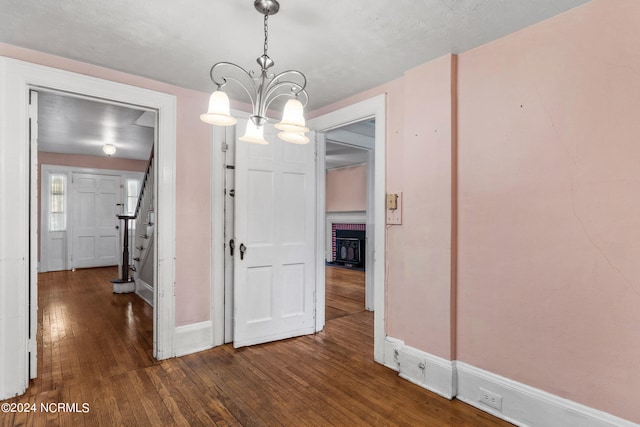 unfurnished dining area with dark wood-type flooring and a chandelier