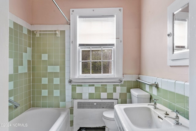 bathroom with plenty of natural light, sink, radiator, and tile walls