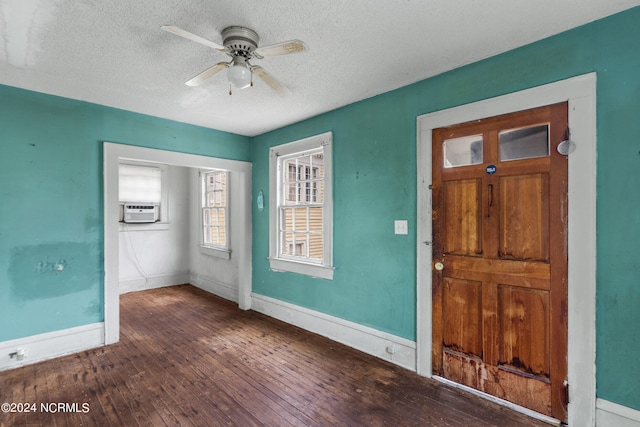 interior space with a textured ceiling, ceiling fan, cooling unit, and dark hardwood / wood-style flooring