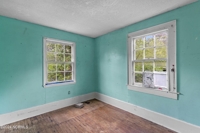 unfurnished room featuring a textured ceiling and wood-type flooring