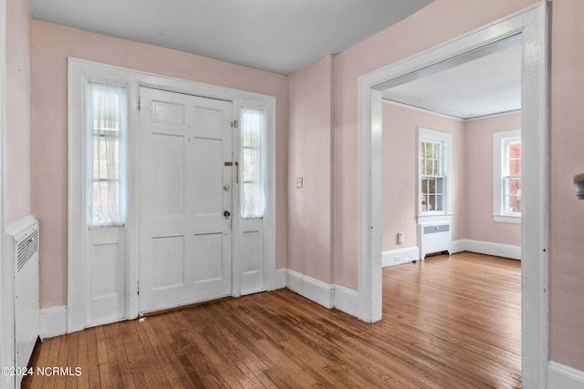 foyer entrance featuring hardwood / wood-style floors and radiator heating unit