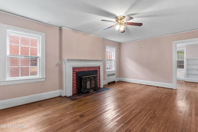 unfurnished living room featuring a textured ceiling, radiator, ceiling fan, and wood-type flooring