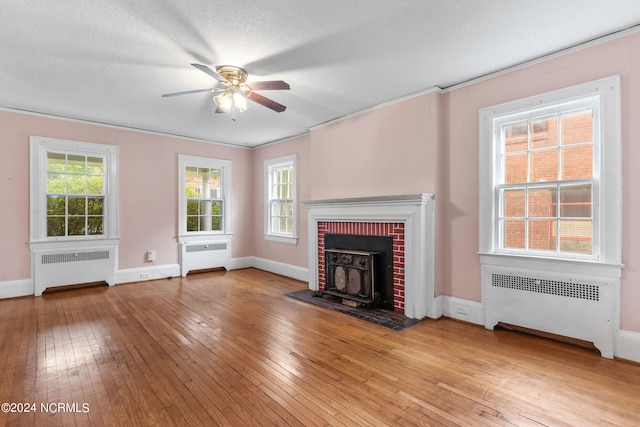 unfurnished living room with radiator heating unit, ceiling fan, and light hardwood / wood-style flooring