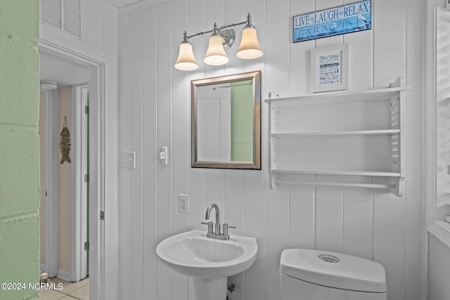 bathroom with sink, toilet, crown molding, and tile patterned flooring