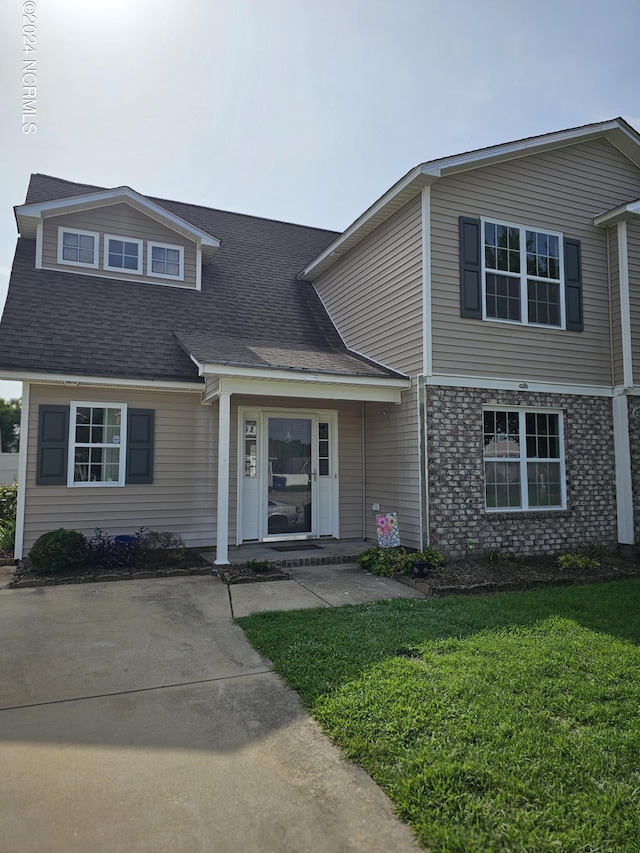 view of front of home with brick siding and a front yard