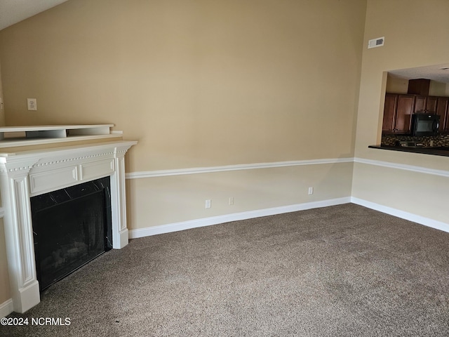 unfurnished living room with carpet flooring and lofted ceiling