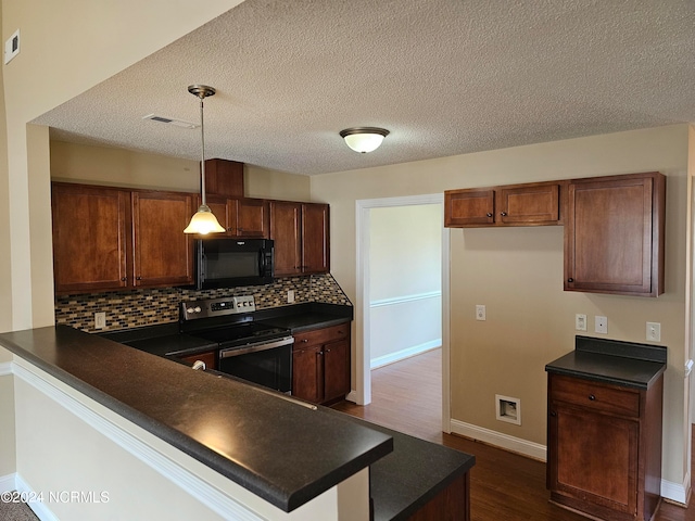 kitchen with a textured ceiling, dark wood-type flooring, electric stove, decorative backsplash, and pendant lighting