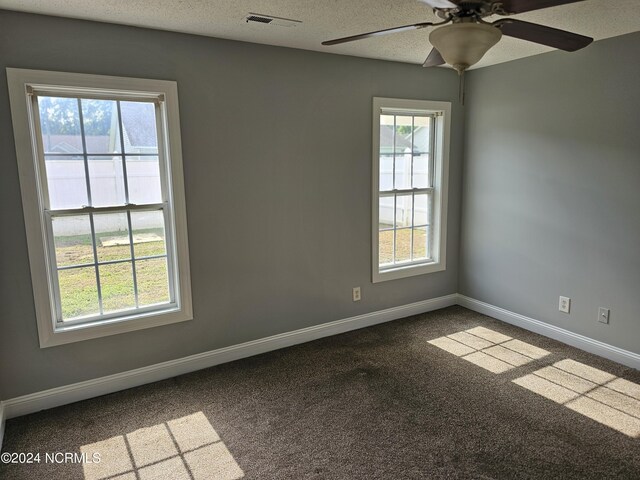 unfurnished room with a textured ceiling, carpet, and ceiling fan