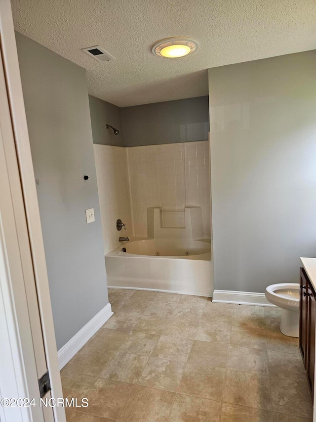 full bathroom featuring tile patterned floors, vanity, tiled shower / bath combo, and toilet