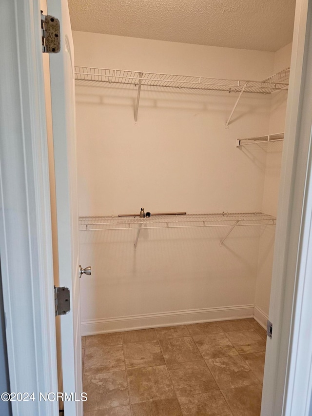 spacious closet with tile patterned floors