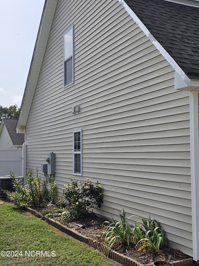 view of side of property featuring a shingled roof and central air condition unit