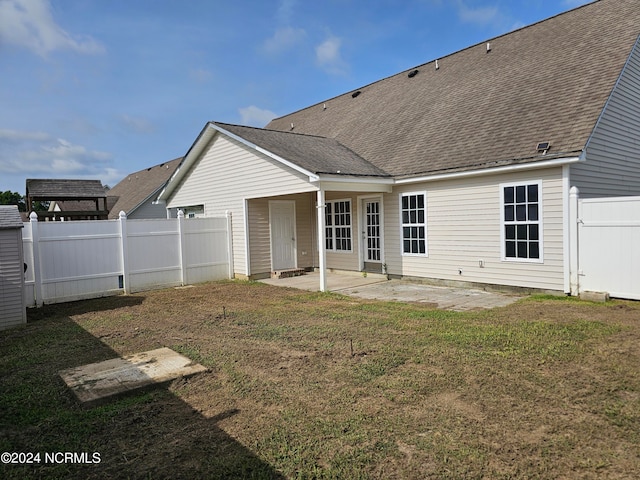 rear view of property featuring a yard and a patio area