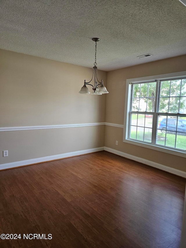 interior space featuring dark hardwood / wood-style floors, a notable chandelier, and a textured ceiling