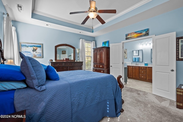 bedroom with light carpet, ensuite bathroom, ornamental molding, a tray ceiling, and ceiling fan