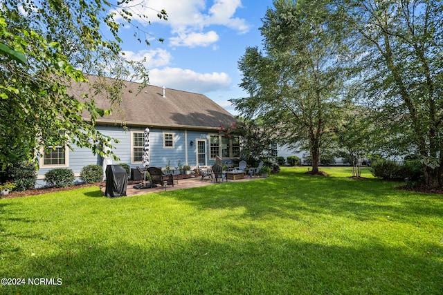 rear view of property featuring a yard and a patio