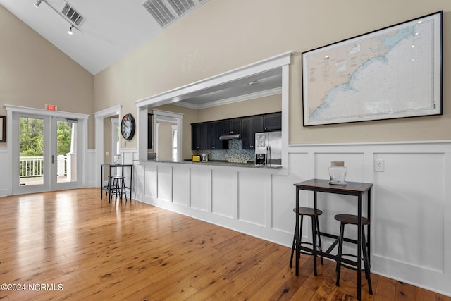 living room featuring french doors, hardwood / wood-style flooring, high vaulted ceiling, and crown molding