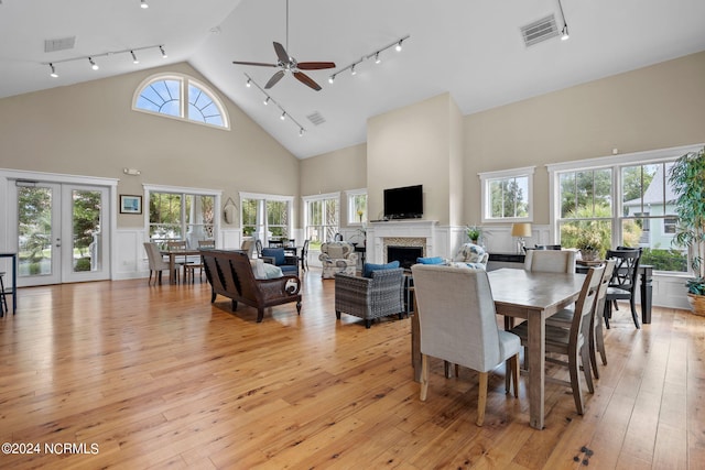 dining area with ceiling fan, french doors, rail lighting, light hardwood / wood-style flooring, and high vaulted ceiling