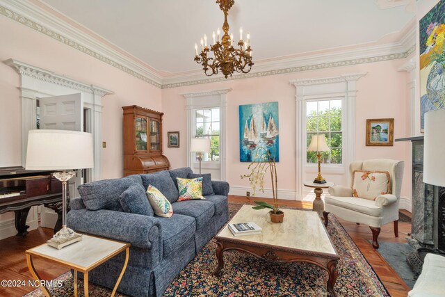 living room featuring hardwood / wood-style floors, a chandelier, crown molding, and a healthy amount of sunlight