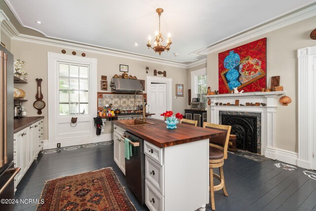 kitchen featuring white cabinetry, crown molding, sink, butcher block countertops, and dark wood-type flooring