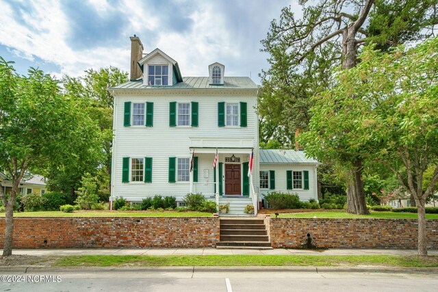 613 Broad St, New Bern, NC 28560 - colonial home featuring a standing seam roof, a chimney, and metal roof