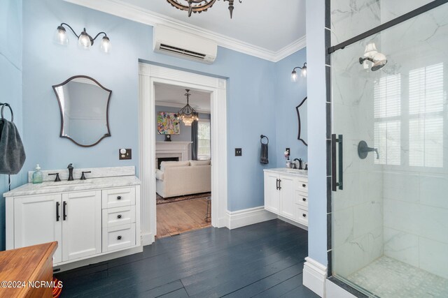 bathroom with an AC wall unit, a shower with door, crown molding, dual vanity, and hardwood / wood-style floors