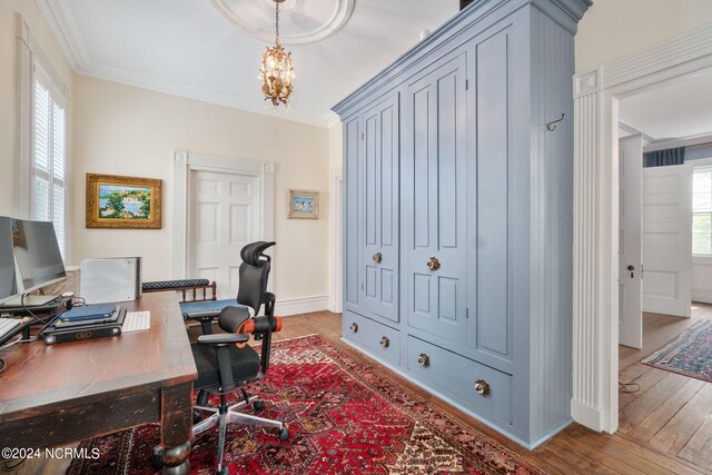 office space with a notable chandelier, light hardwood / wood-style flooring, and ornamental molding