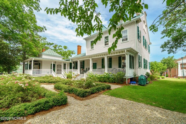 back of house with a porch and a yard