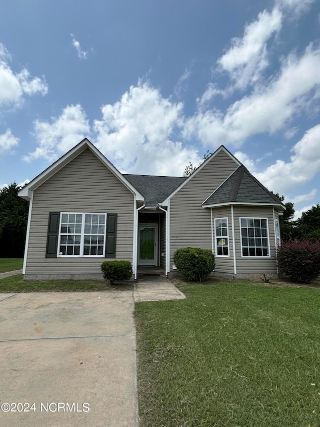 single story home featuring a front lawn