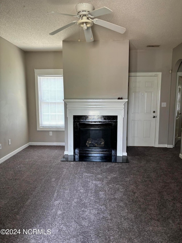 unfurnished living room with a textured ceiling, ceiling fan, and carpet flooring