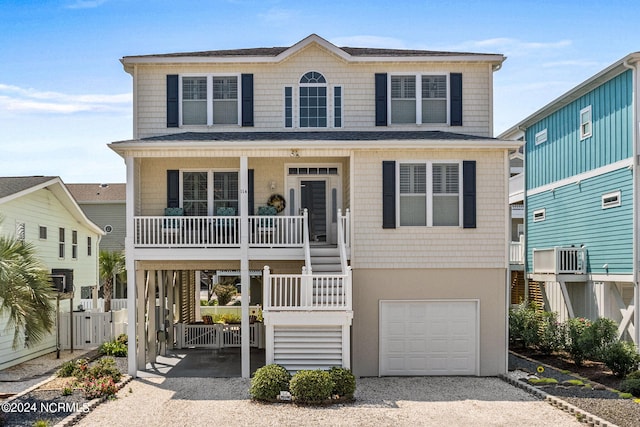 view of front facade with a porch, a garage, and a carport