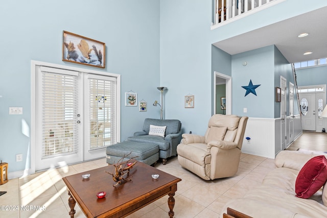 living room featuring a high ceiling, light tile patterned floors, and french doors