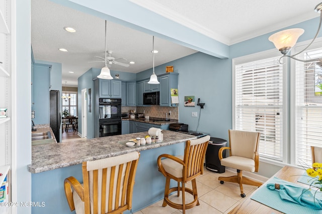 kitchen with a breakfast bar, sink, kitchen peninsula, decorative backsplash, and black appliances