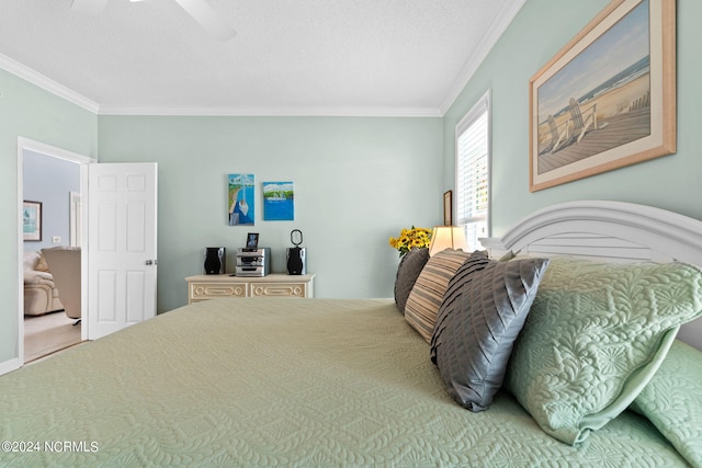 bedroom with ceiling fan, ornamental molding, and a textured ceiling