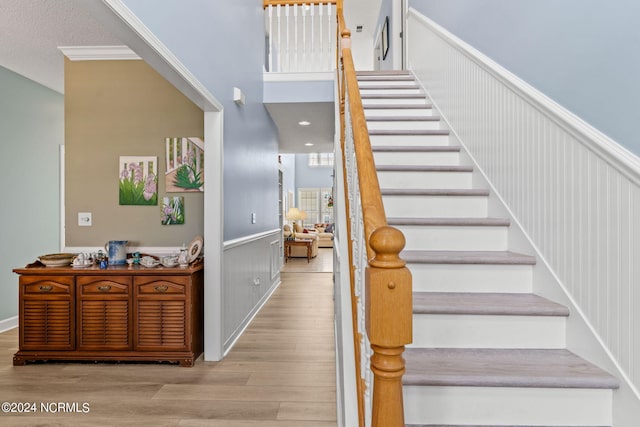 staircase featuring wood-type flooring and a textured ceiling