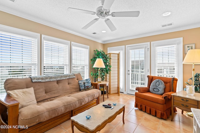 living room featuring light tile patterned floors, ornamental molding, a textured ceiling, and ceiling fan