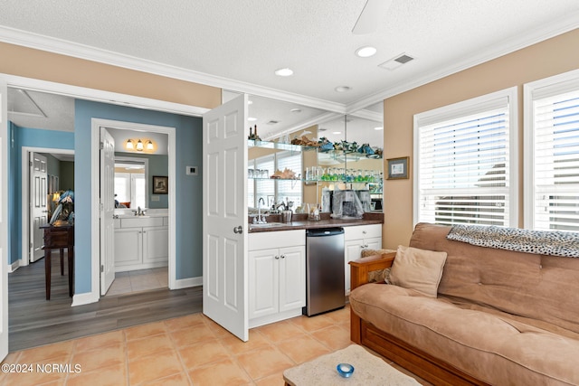 bar with ornamental molding, light tile patterned floors, white cabinets, and a textured ceiling