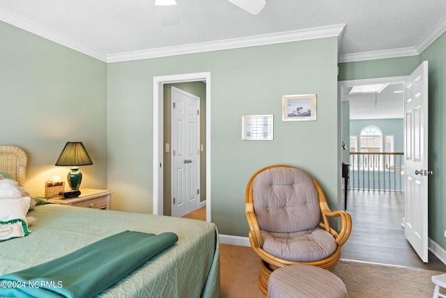 bedroom with crown molding, a textured ceiling, and light wood-type flooring