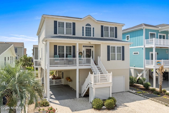 coastal home with a garage, a carport, and covered porch