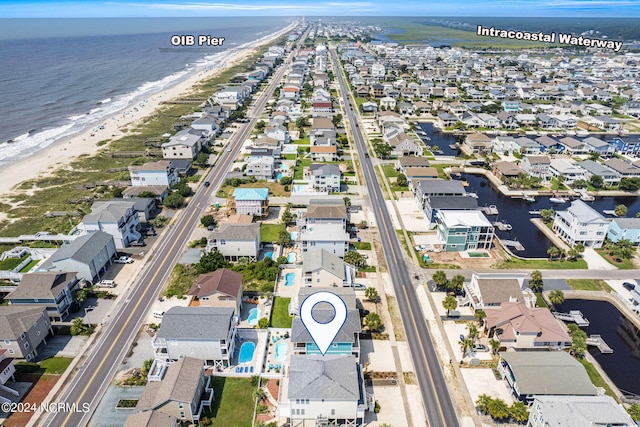 birds eye view of property with a water view and a view of the beach