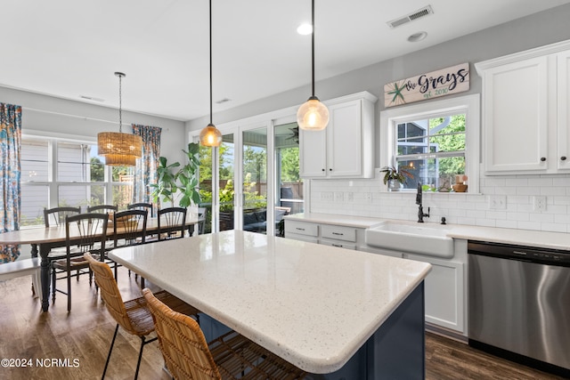 kitchen featuring a center island, white cabinetry, stainless steel dishwasher, and hanging light fixtures