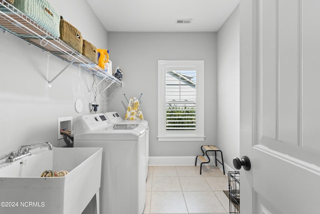 laundry area with washer and clothes dryer, light tile patterned floors, and sink