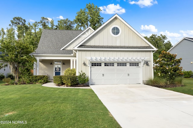 view of front facade with a garage, a shingled roof, concrete driveway, a front lawn, and board and batten siding