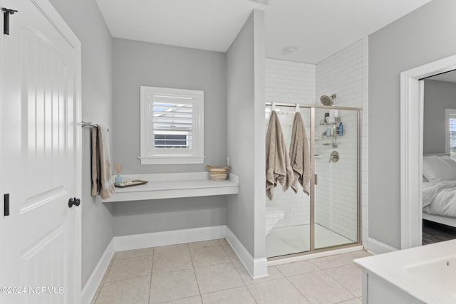 bathroom featuring tile patterned flooring, vanity, and walk in shower