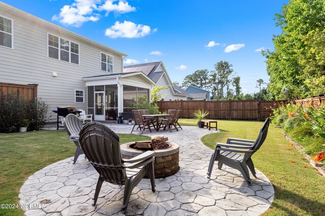 view of patio with a fire pit and a sunroom