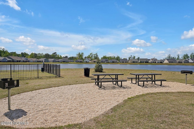 view of property's community with a lawn and a water view