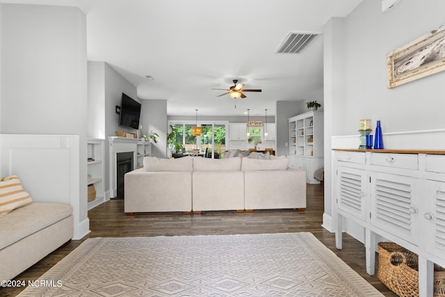 living room featuring ceiling fan and dark hardwood / wood-style floors