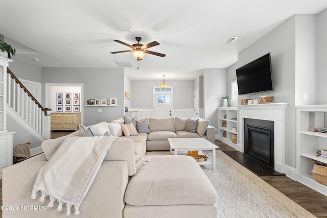 living room featuring dark hardwood / wood-style flooring and ceiling fan