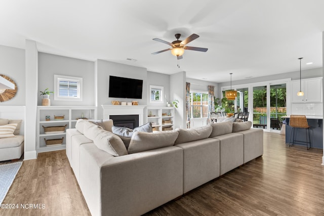 living room featuring ceiling fan and dark wood-type flooring