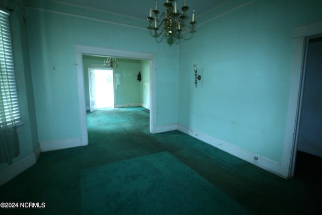 unfurnished room with a chandelier and carpet